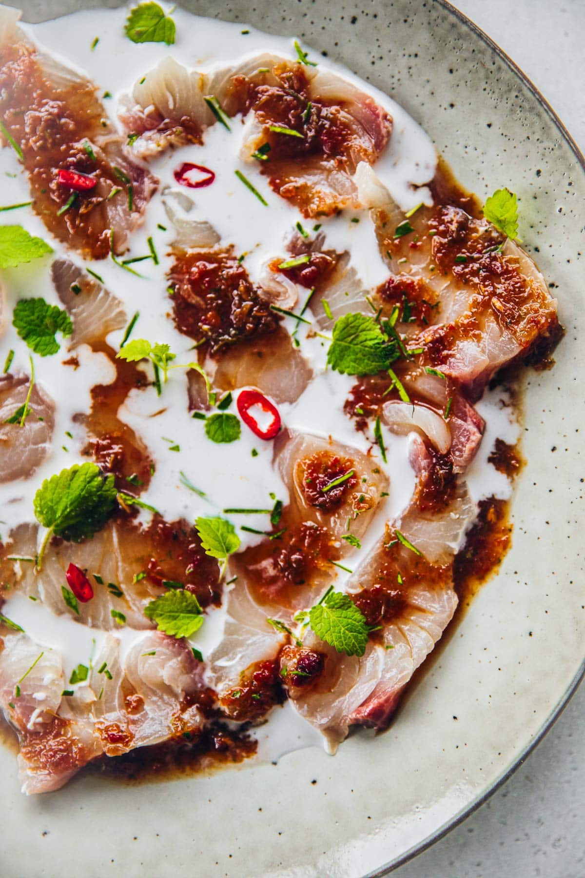 Delicious Kingfish Ceviche served in a plate topped with chilli, herbs and lime.